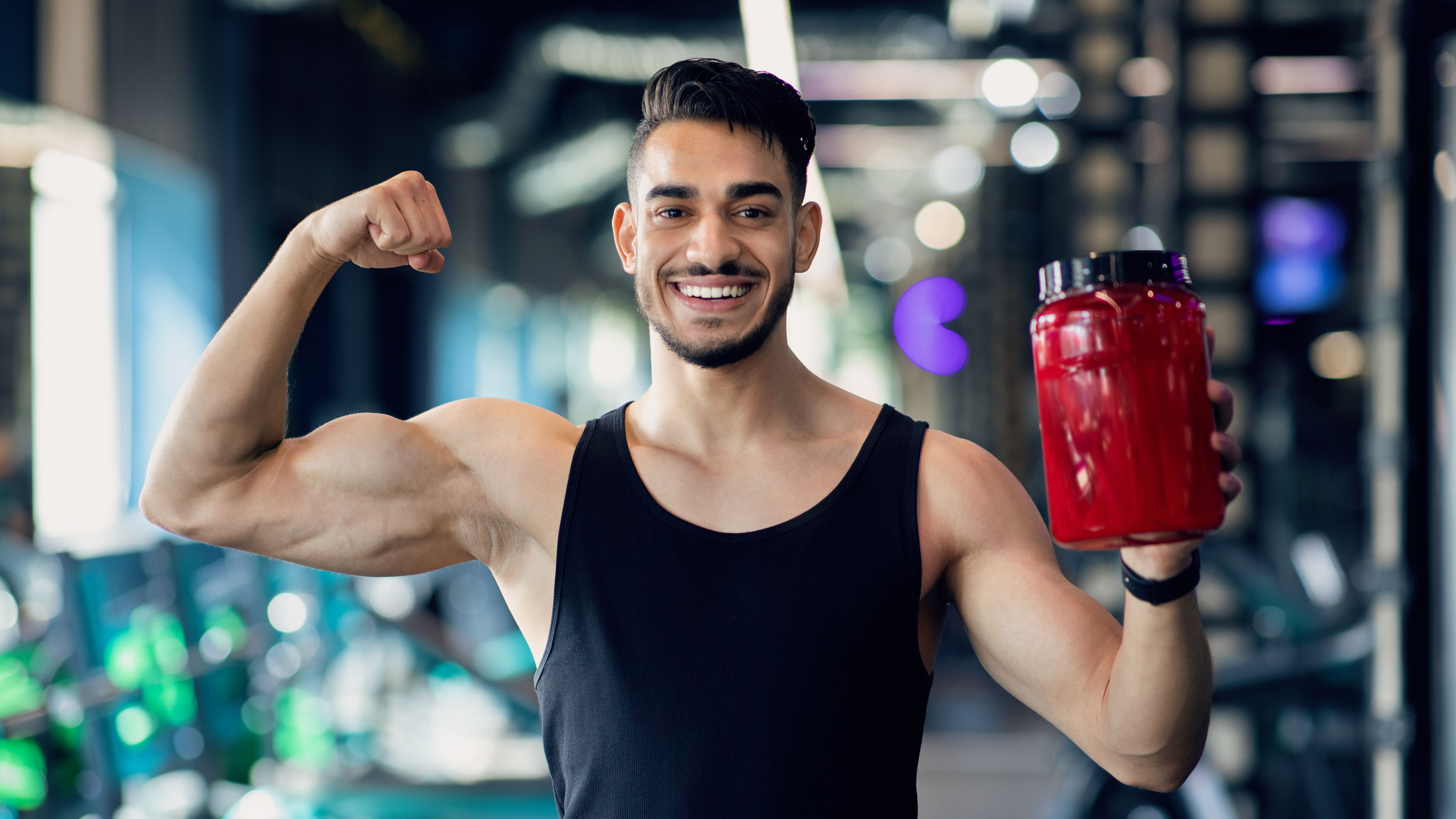 A man holding shake bottle at the gym