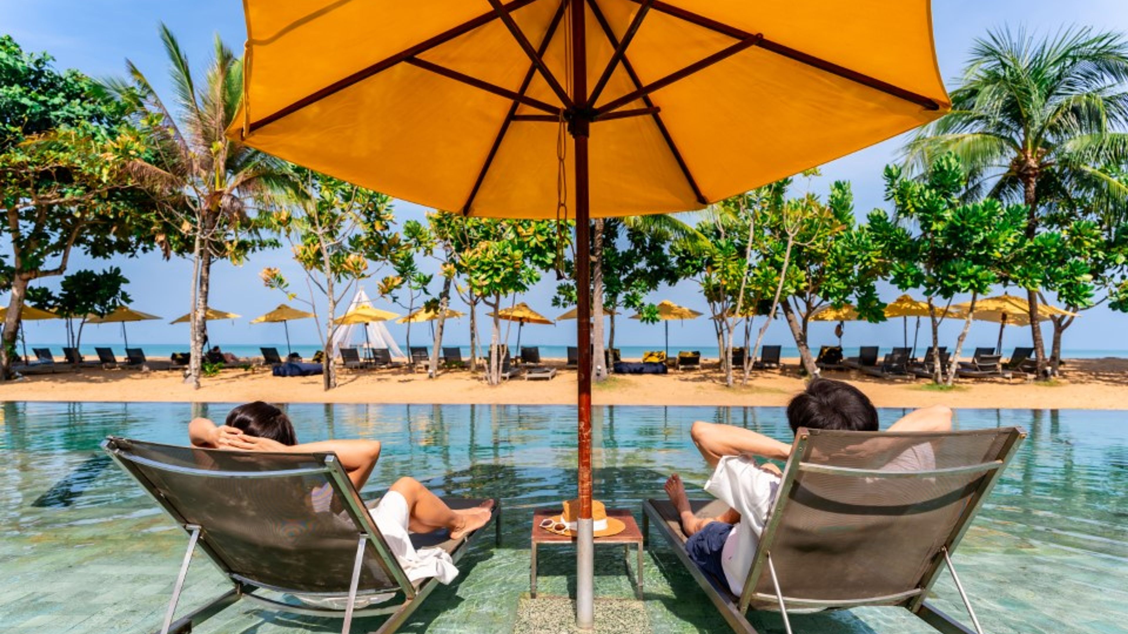 स्विमिंग पूल के पास बैठे कपल 